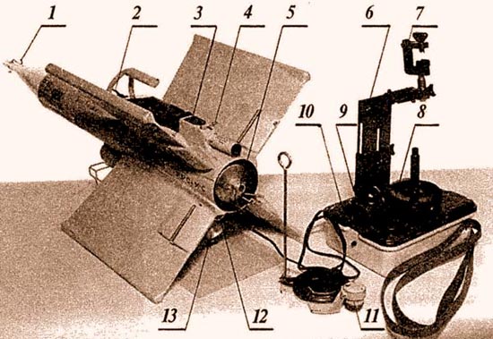 ПТУРС «Кобра» в боевом положении: 1 – головная часть взрыва-тельного устройства; 2 – транспорти-ровочная рукоятка; 3 – контрольный бортразъем; 4 – стопорный шплинт трассера; 5 – сопло маршевого двигателя; 6–регулируемая по высоте стойка прицела; 7 – струбцина для крепления полевого бинокля; 8 – крышка аккумуляторной батареи; 9 – электро-разъем кабеля управления; 10 – кнопка «пуск»; 11 – бортовой электроразъем кабеля управления; 12 – шунт запальной электроцепи двигателя; 13 – наклонное сопло стартового двигателя